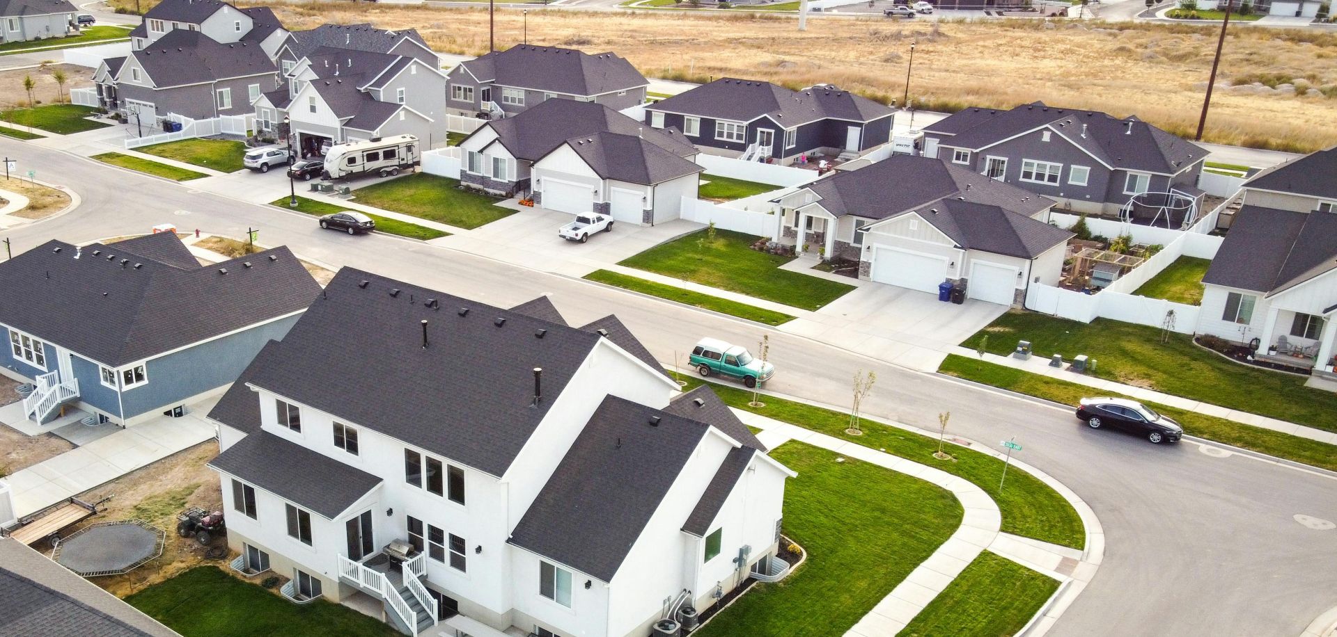 Scenic aerial view of a residential area in Spanish Fork, Utah featuring modern houses and green lawns.